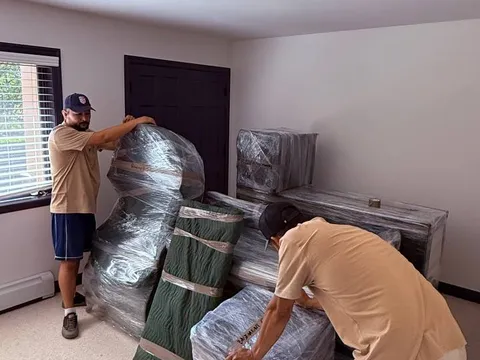 Sun City Moving crew members wrapping furniture inside a home
