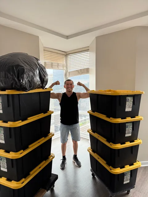 One of the Sun City Moving owners on a job, between two stacks of packed storage bins