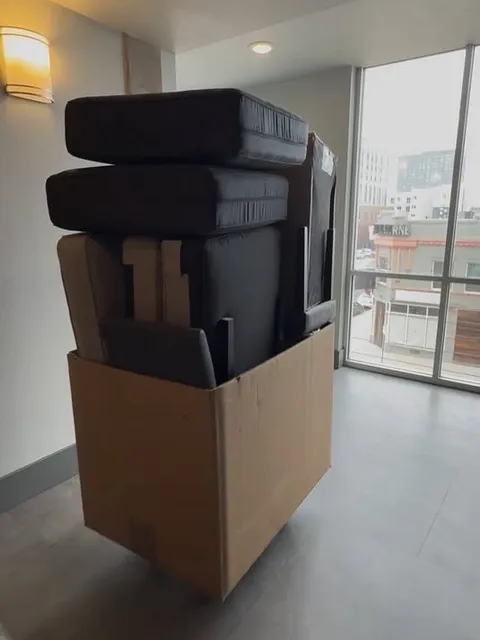 Sofa cushions and frame pieces packed into a large box for the move