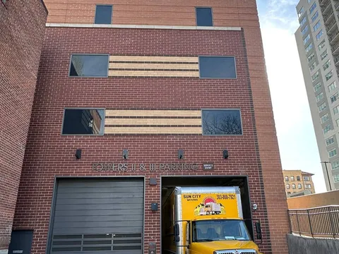 A Sun City Moving truck parked in a downtown building's loading area