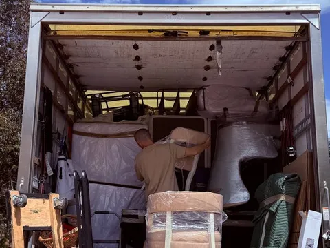 A Sun City Moving crew member loading furniture inside the truck