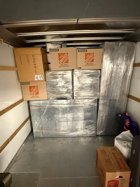 A Sun City Moving truck loaded with boxes and wrapped furniture, packed tight from floor to ceiling