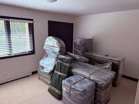 Furniture fully wrapped and staged in an empty room before loading