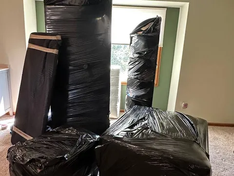 Furniture wrapped in protective plastic in a living room